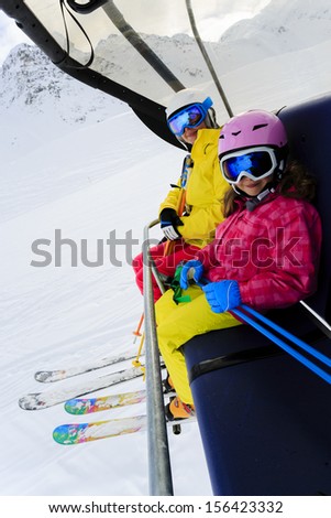 Ski lift, skiing, ski resort - happy skiers on ski lift