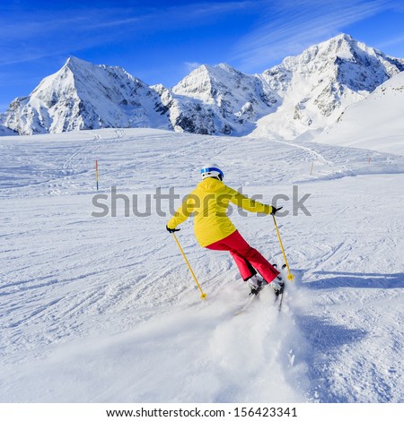 Ski, skier on ski run - woman skiing downhill, winter sport