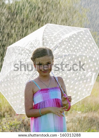 Rain - happy girl with an umbrella in the rain