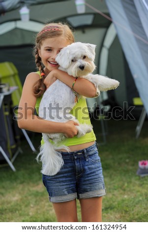 Camp in the tent - young girl playing with dog on the camping