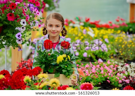 Gardening, planting - Lovely girl holding flowers in garden center.