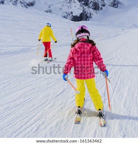 Skiing, skiers on ski run - female skiers skiing downhill,  child on ski lesson