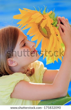 Girl and sunflower - beautiful girl is smelling sunflower in the garden