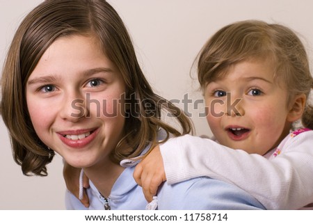 Happy sisters playing, piggyback