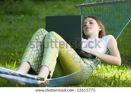 Cute girl at computer in the garden