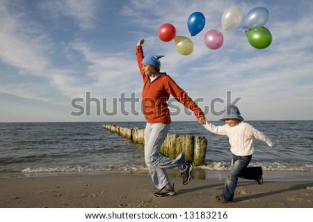 Family playing with balloons on the beach