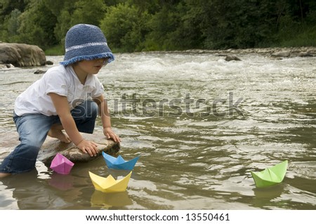 stock-photo-cute-girl-playing-with-paper-boats-13550461.jpg
