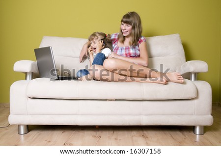 Sisters with laptop on sofa