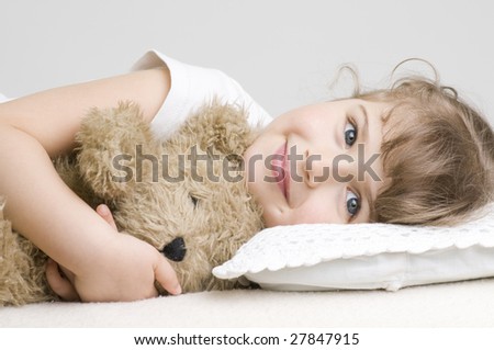 Little girl with bear on sofa