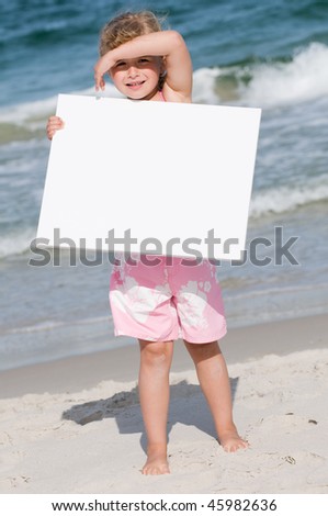 Little girl with whiteboard at the beach