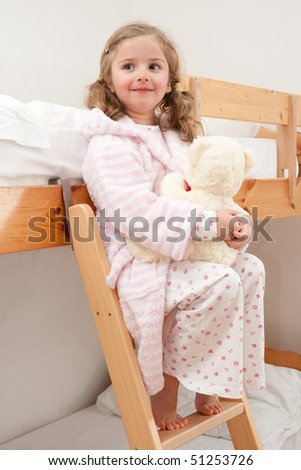 Cute girl in pyjama hugging no-name teddy bear