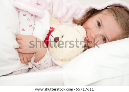 Little girl in bed hugging no-name teddy bear