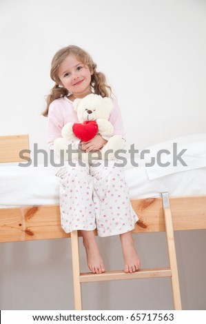 Cute girl in pyjamas hugging no-name teddy bear