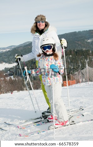 Little girl with mother on ski