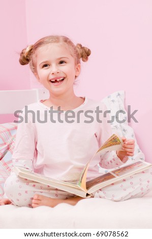 Story time - little girl reading book in bed