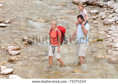 Mountain trek - family crossing  through mountain river