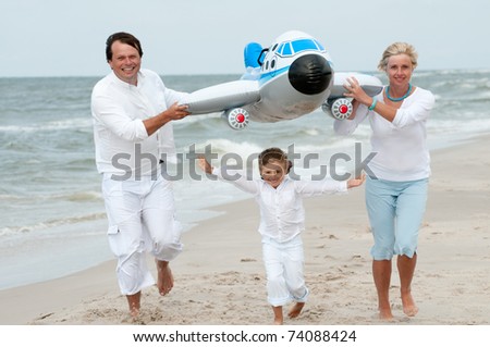 Travel - happy family playing at the beach (no-name inflatable toy)