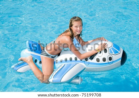 Young girl playing in blue water - no name inflatable toy