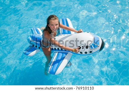 Young girl playing in blue water - no name inflatable toy