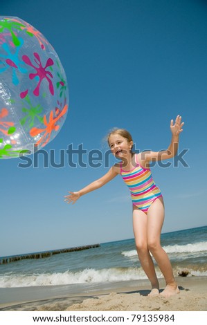 Summer vacation - little girl  playing on the beach (no name inflatable ball)