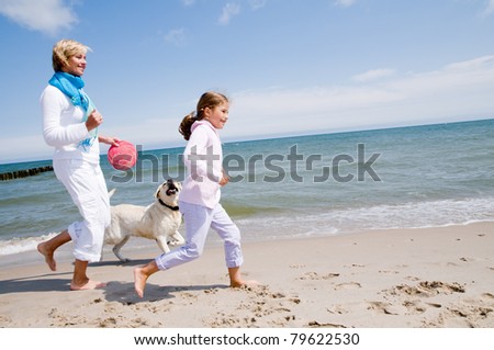 Summer vacation - family with dog playing on the beach