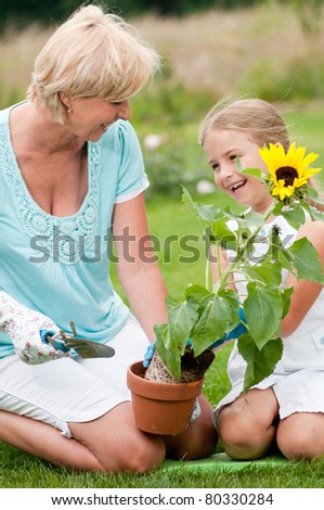 Gardening - Happy mother with daughter working in garden