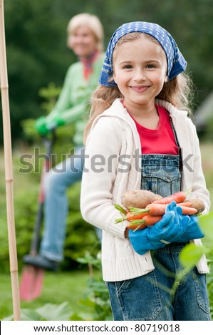 Gardening - little girl with mother working in vegetable garden