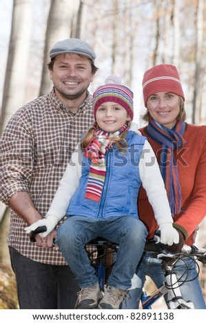Autumn biking -happy family biking in autumn forest