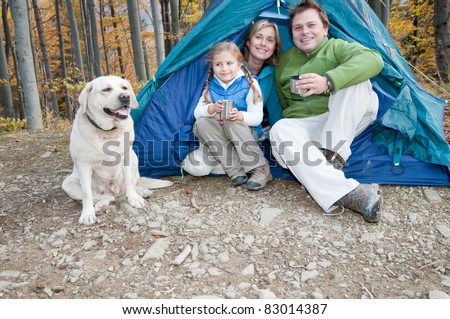 Camping in tent - family with dog camping in autumn forest