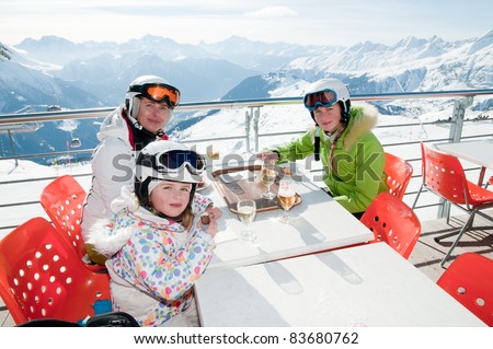 Winter, ski - family enjoying lunch in winter mountains