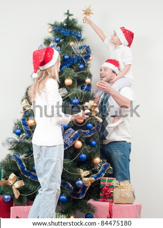 Happy Christmas - Family decorating a Christmas tree