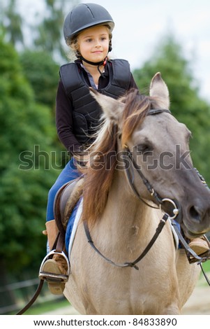 Horseback riding - little girl is riding a horse