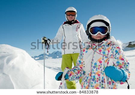 Winter skiing - girl skiing with mother in ski resort