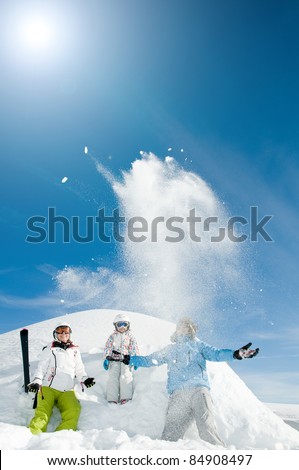 Winter, snow, sun and fun - happy skiers playing in snow