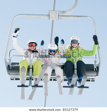 Ski lift - happy skiers on ski vacation