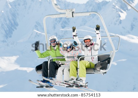 Ski lift - happy skiers in ski resort