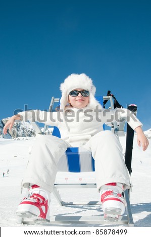 Happy winter vacation - little skier in ski resort (copy space, cover)
