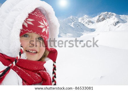 Winter holiday - portrait of cute girl, snowy mountains in background (space for text)