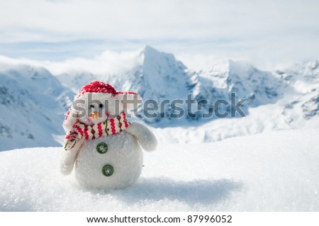 Winter, holiday - Happy snowman  in mountains (copy space)