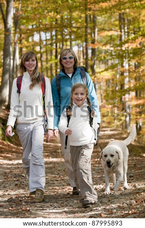 Autumn walking in forest - family with dog on trek