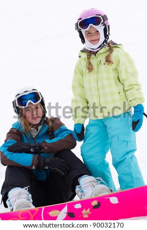 Winter, snowboarding - portrait of young snowboarder girls on ski slope