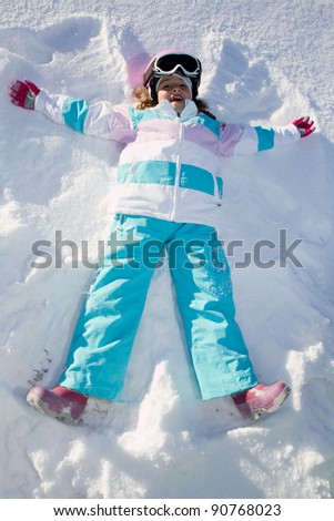 Winter fun - Snow Angel - little girl playing in snow