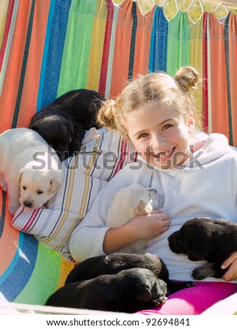 Happy childhood - little girl with cute puppies in hammock