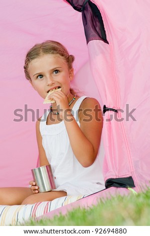 Camping in tent - happy girl on camp tent