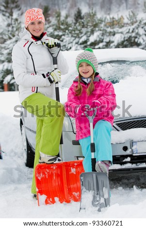 Winter, snow - family is shoveling the road and the car of snow
