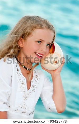 Summer holiday - lovely girl with shell at the beach