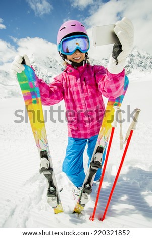 Ski, selfie, winter fun - lovely skier girl enjoying ski vacation