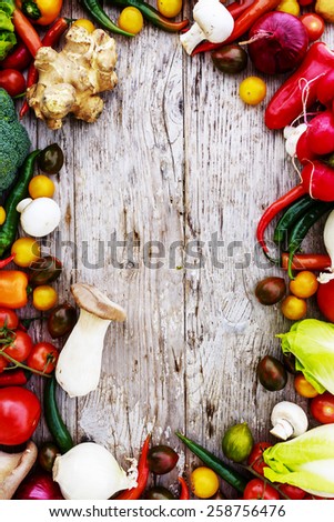 Frame of various vegetables over a rustic wooden background with copyspace