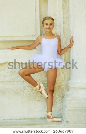 Beautiful ballet-dancer in white dress and pointe shoes dancing in Venice Italy