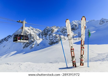Skiing, winter season - mountains, cable car and ski equipments on ski run